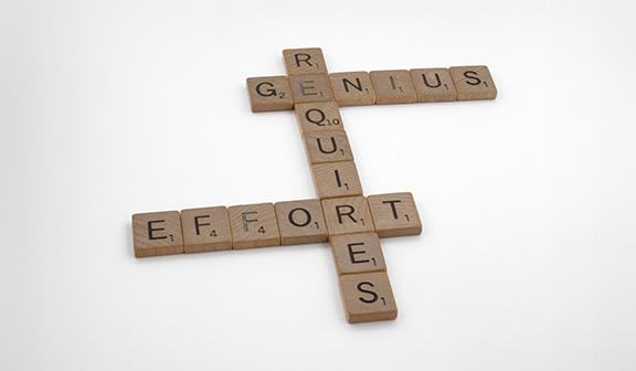 Scrabble tiles saying genius requires effort